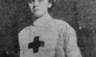 Portrait of nurse Margaret Birkett standing in uniform