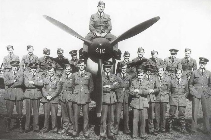 A large group of RAF pilots from the 610 Spitfire Squadron from Biggin Hill, standing by a spitfire aircraft